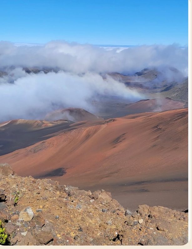 Maui crater with clouds rolling over red earth