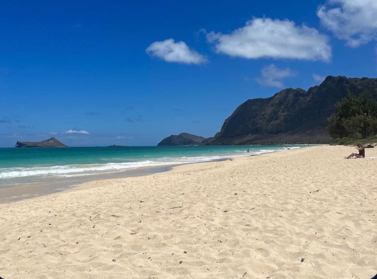 White-sand beach with green hills